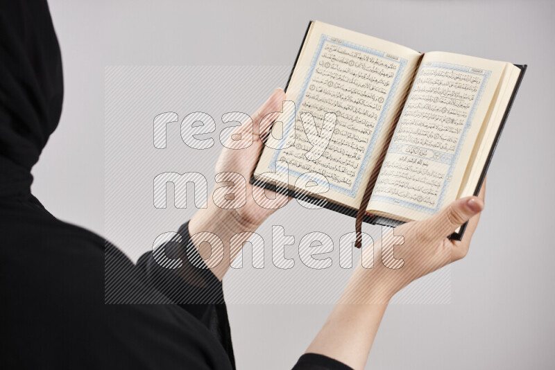 A woman hands holding moshaf in different positions