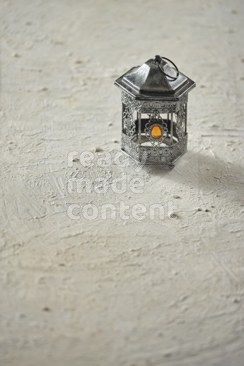 A lantern placed on a textured white background
