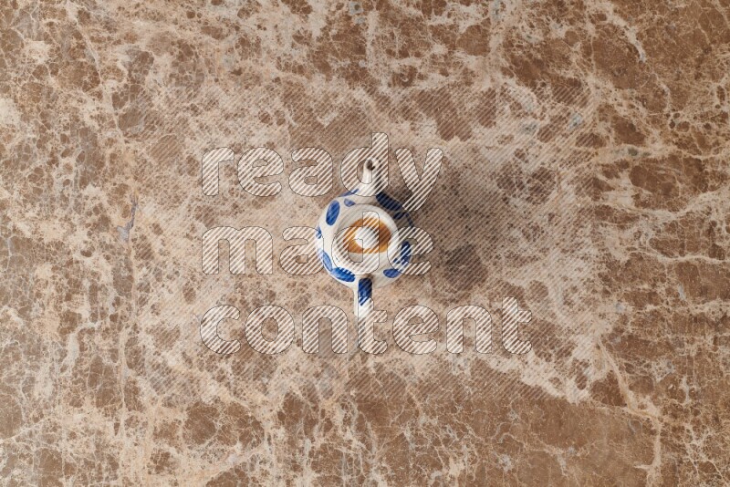 A pottery teapot on beige marble background