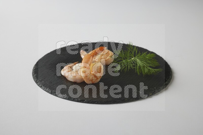 three grilled shrimp  on a black slate direct  on a white back ground