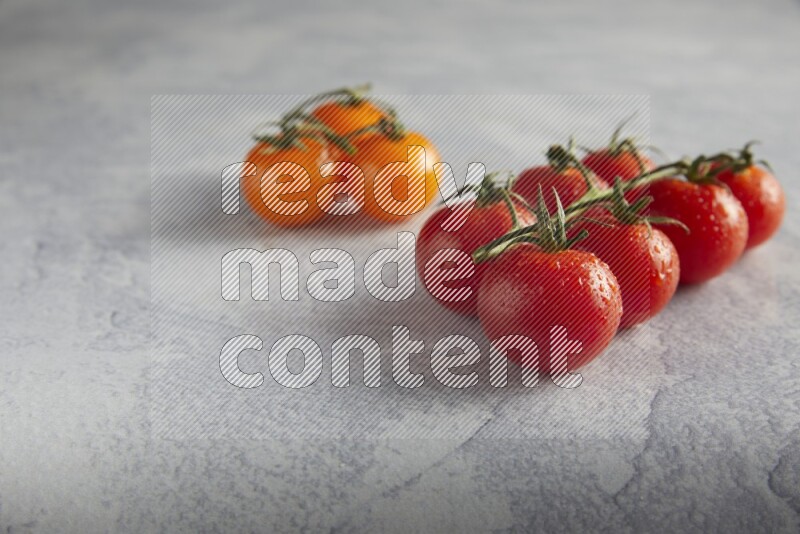 Mixed cherry tomato veins on a textured light grey background 45 degree