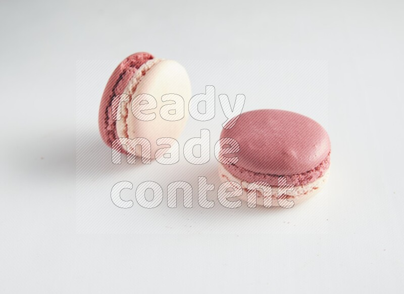 45º Shot of two Pink Litchi Raspberry macarons on white background