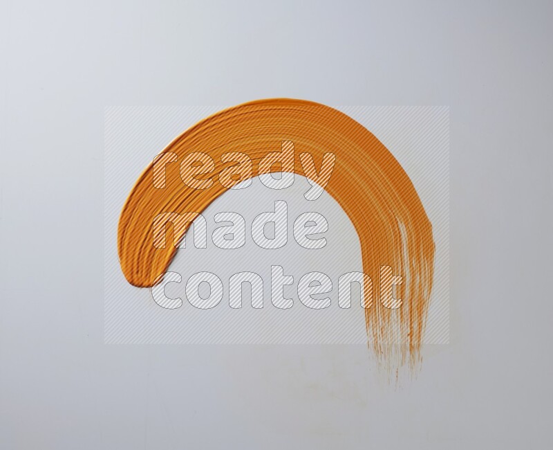 An orange half circular painting brush stroke on white background