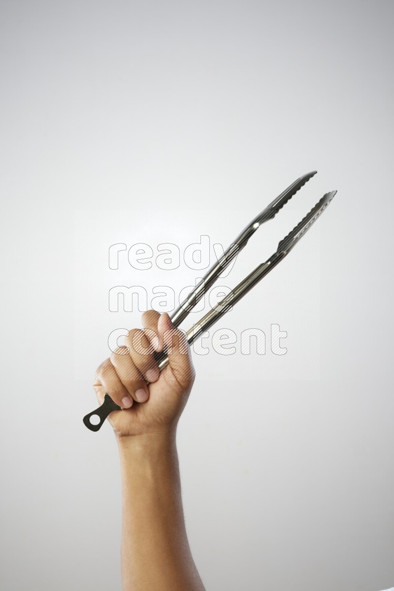 Male Hand Holding Tongs on white background