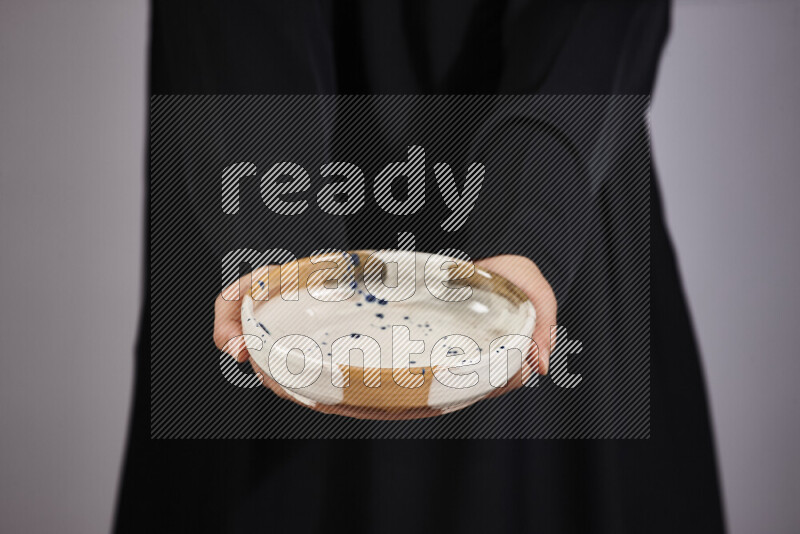 امرأة ترتدي عباءة سوداء تحمل أدوات فخارية مختلفة في أوضاع متعددة