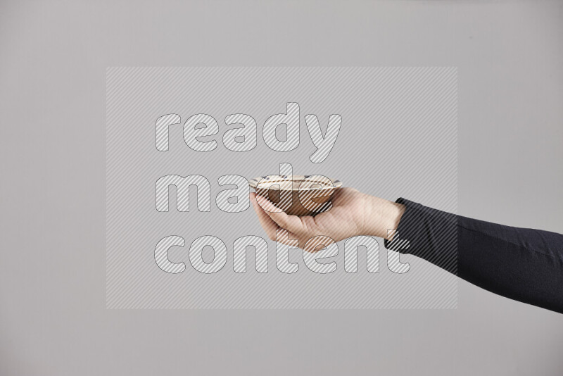 A woman in black abaya holding different pottery essentials in different positions