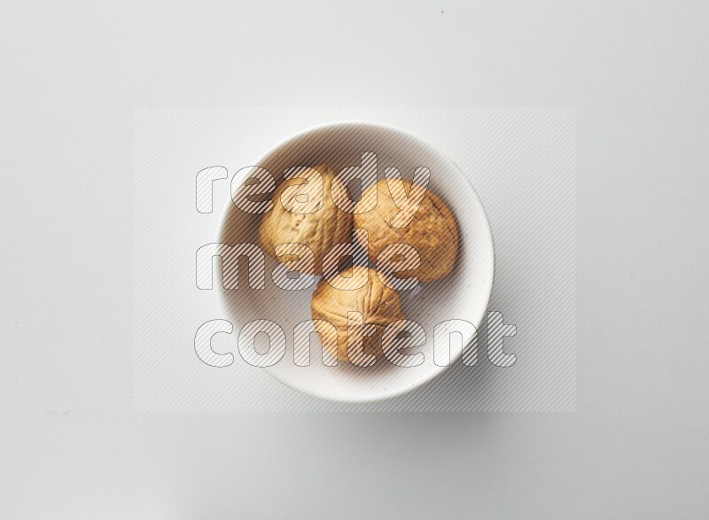 Top-view shot of walnut in a container on white background