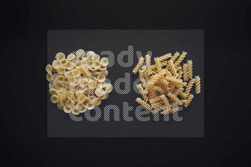 Different pasta types in bunches on black background