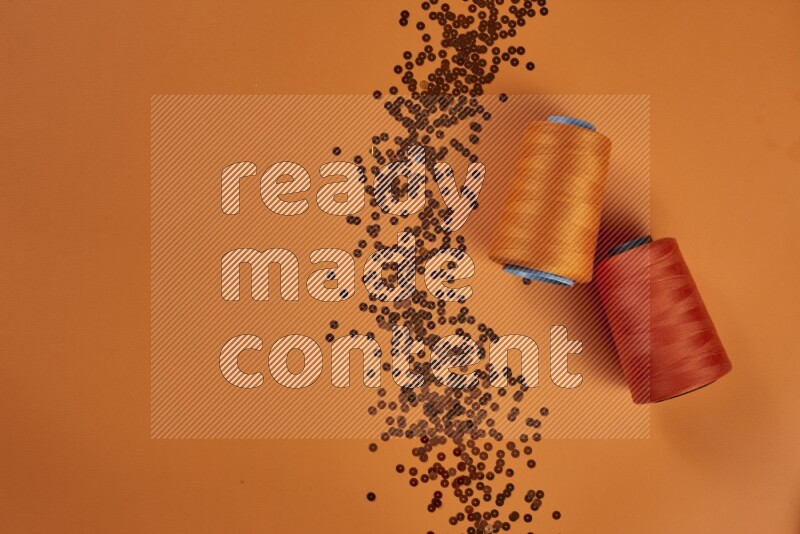 مجموعة من أدوات الخياطة والتفصيل برتقالية اللون على خلفية برتقالية