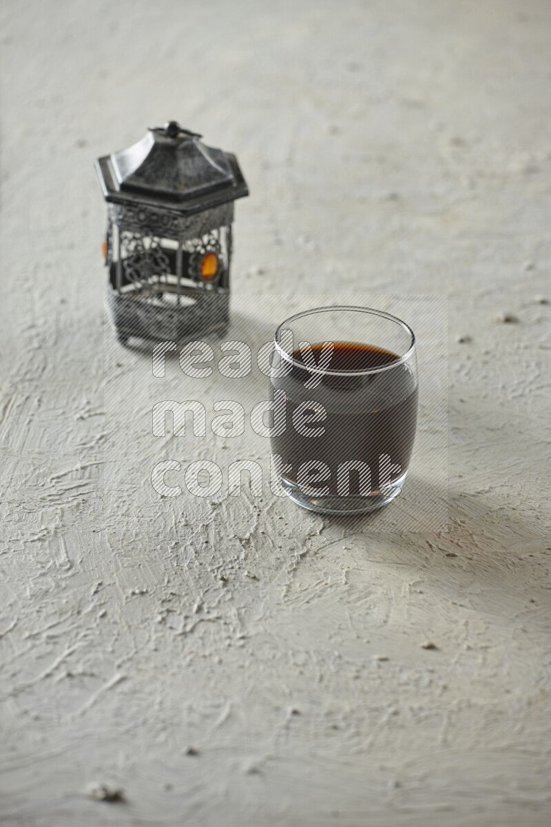 فانوس فضي مع مشروبات مختلفة وتمر ومكسرات وسبحة صلاة وقرآن على خلفية بيضاء