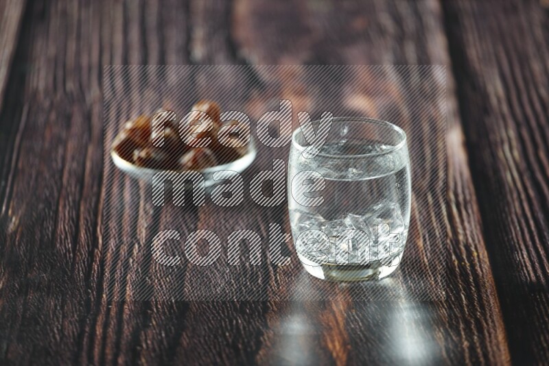 Cold drinks in a glass cup with dates such as water, tamarind, qamar eldin, sobia, milk and hibiscus on wooden background