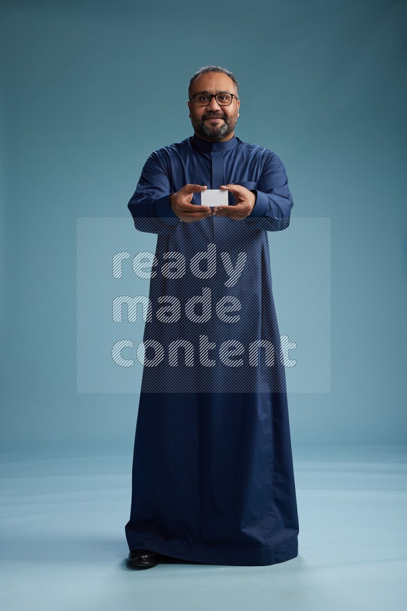 Saudi Man without shimag Standing holding ATM on blue background
