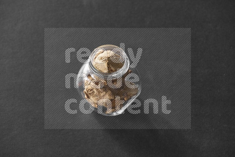 زنجبيل مجفف في وعاء زجاجي علي خلفية سوداء