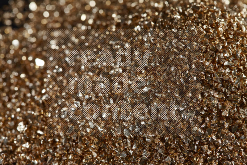 قطع زجاجية ذهبية لامعة متناثرة على خلفية سوداء