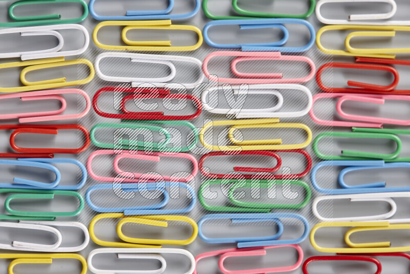 Multicolored paper clips isolated on a grey background
