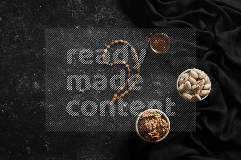 Nuts in pottery bowls with coffee in a dark setup