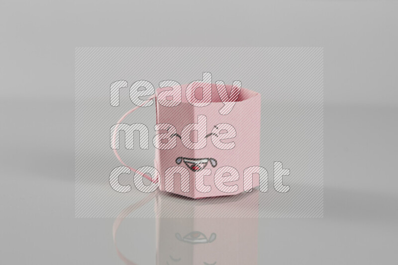 Origami cup on grey background