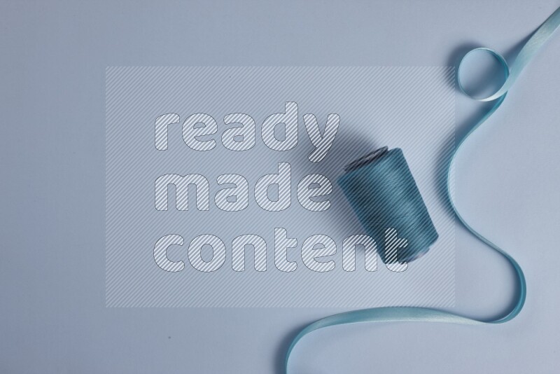 A blue collection of sewing and tailoring tools arranged on a blue background