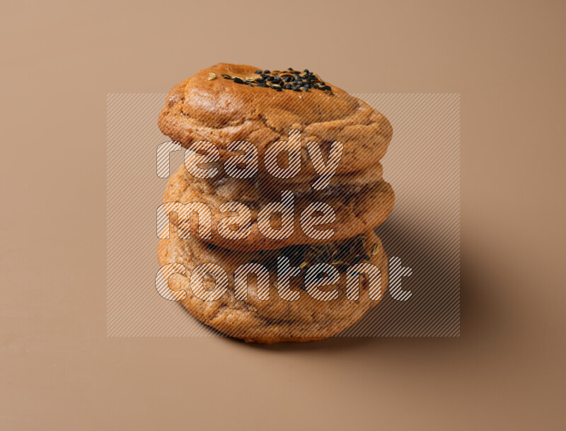 Hasawi cookies field with date and decorated by black seed and Anise grain on a brown background
