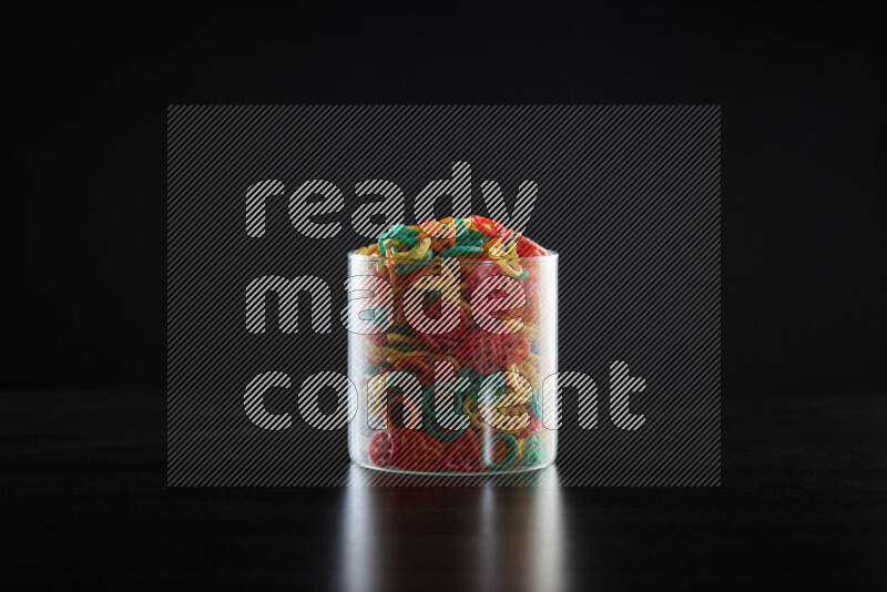 Snacks in a glass jar on black background