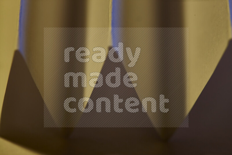 صورة مجردة مقربة تظهر طيات ورقية هندسية حادة بتدرجات الوان دافئة