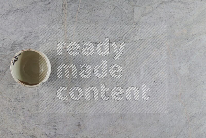 A multicolored pottery Cup on grey marble background