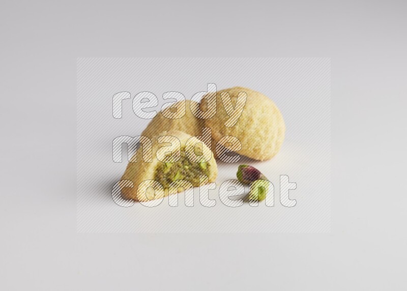 Three Pieces of Maamoul filled with pistachio paste  one of them is cut direct on white background