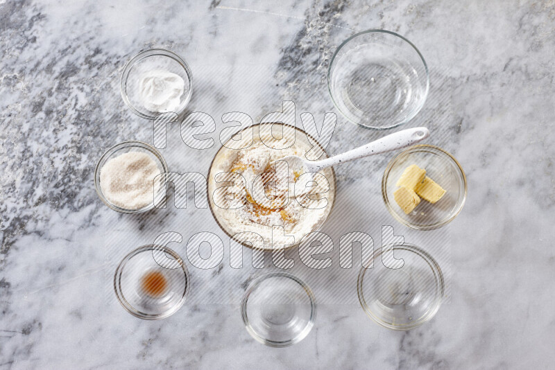 Cookies step by step with its ingredient, flour, butter, brown sugar, egg, vanilla extract, white sugar, chocolate chips and baking soda on grey marble background