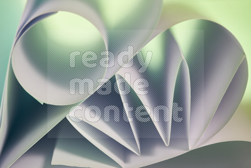 عرض فني لطيات الورق تخلق مزيج من الأشكال الهندسية، مضاءة بإضاءة ناعمة بدرجات اللون الأخضر والأحمر