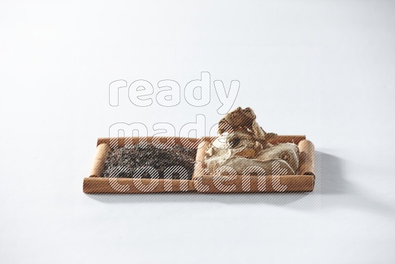 2 squares of cinnamon sticks full of black tea and dried ginger on white flooring