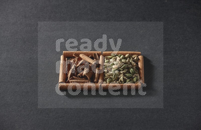 2 squares of cinnamon sticks full of cardamom and cinnamon on black flooring