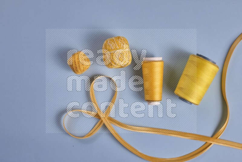 A yellow collection of sewing and tailoring tools arranged on a blue background