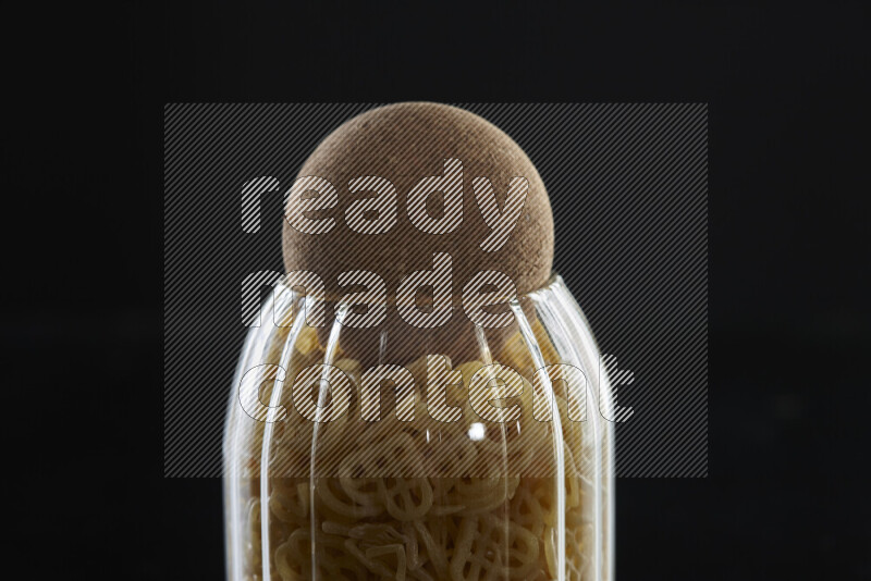 Snacks in a glass jar on black background