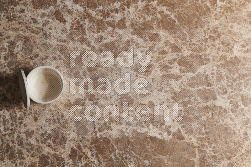 A pottery cup on beige marble background