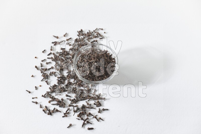 وعاء زجاجي ممتلئ بالقرنفل على أرضية بيضاء