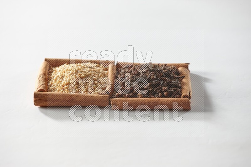 2 squares of cinnamon sticks full of cloves and sesame on white flooring