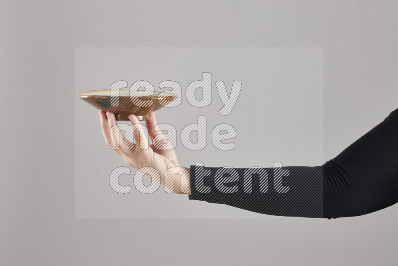 A woman in black abaya holding different pottery essentials in different positions
