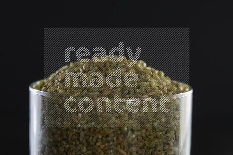 Freekeh in a glass jar on black background