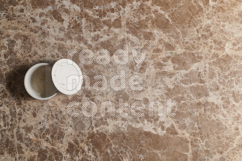 A pottery cup on beige marble background