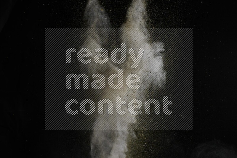 A side view of brown powder explosion on black background