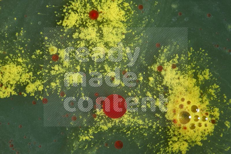 The image captures a dramatic splatter of red, green and yellow paints over the backdrop