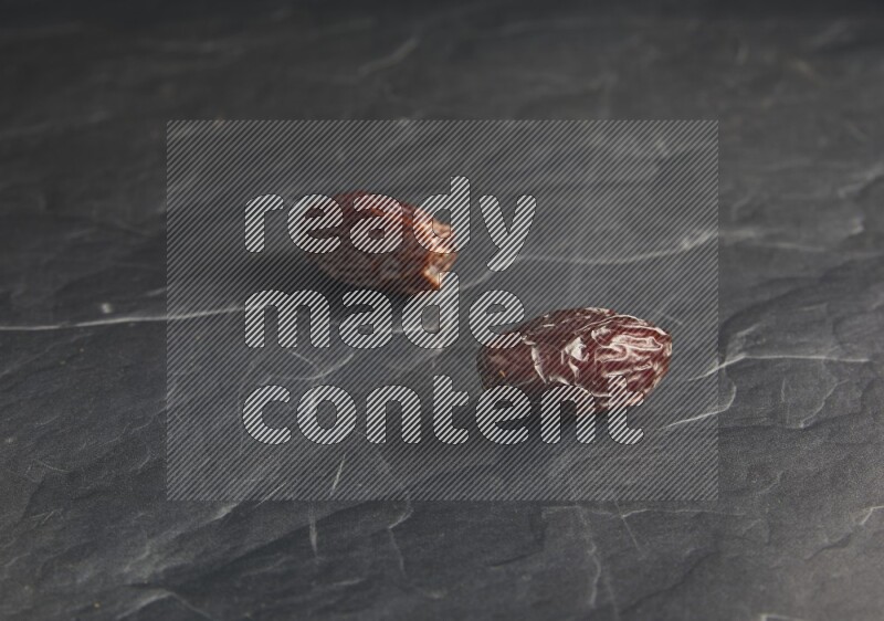 two madjoul dates on a black textured background