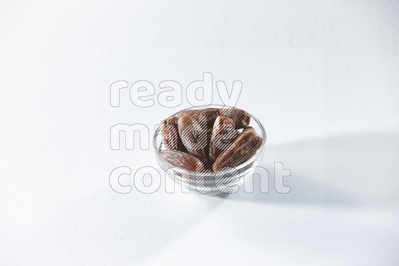 A glass bowl full of dried dates on a white background in different angles