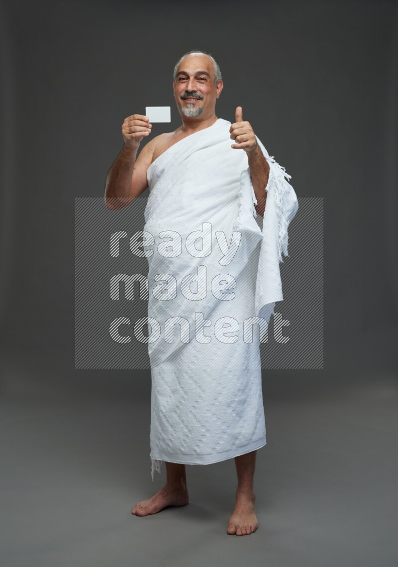 A man wearing Ehram Standing holding ATM card on gray background