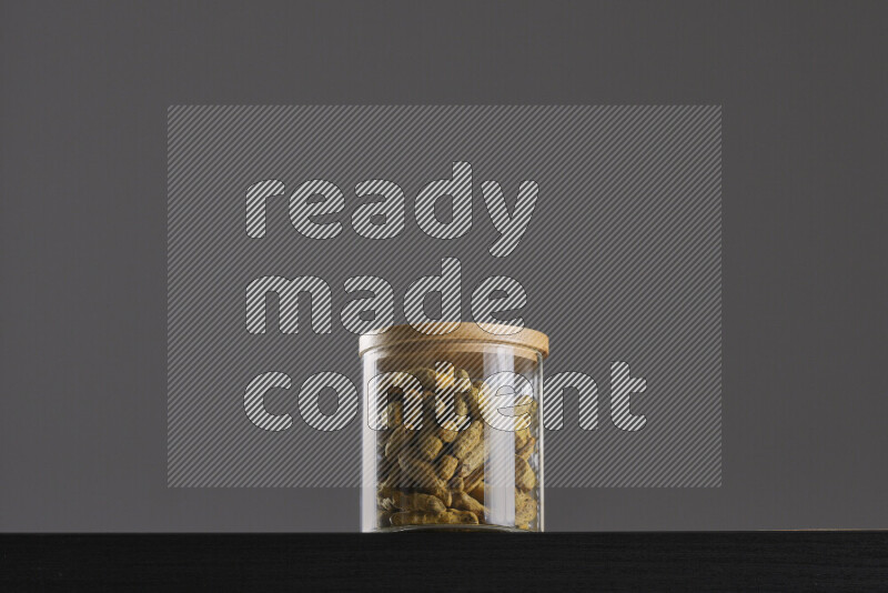 Turmeric in a glass jar on black background