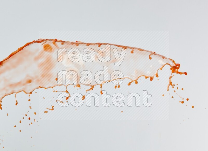 Orange liquid splash and drops on white background