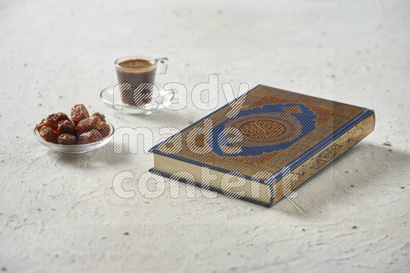 Quran with dates, prayer beads and different drinks all placed on textured white background