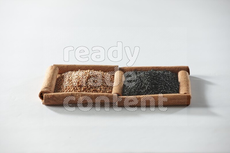 2 squares of cinnamon sticks full of mustard seeds and black seeds on white flooring