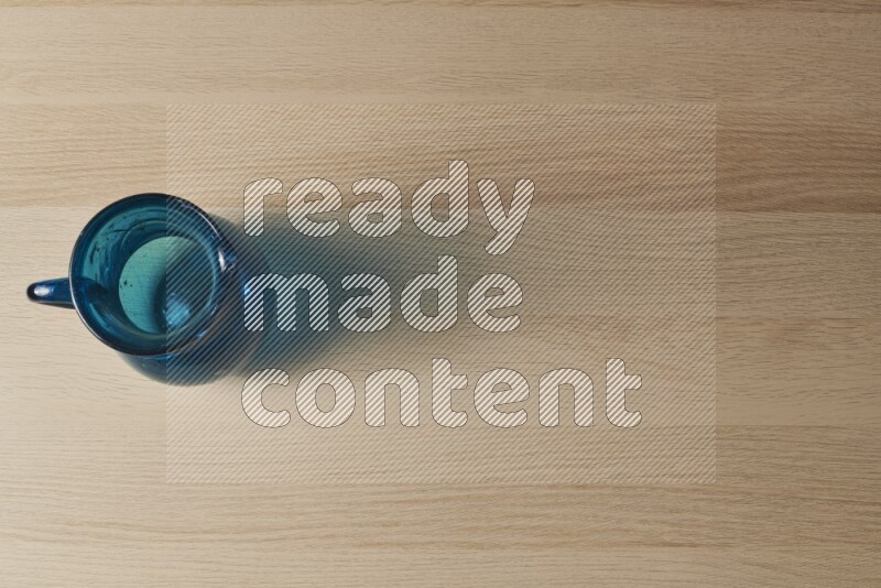 A colored glass jug on light wooden background
