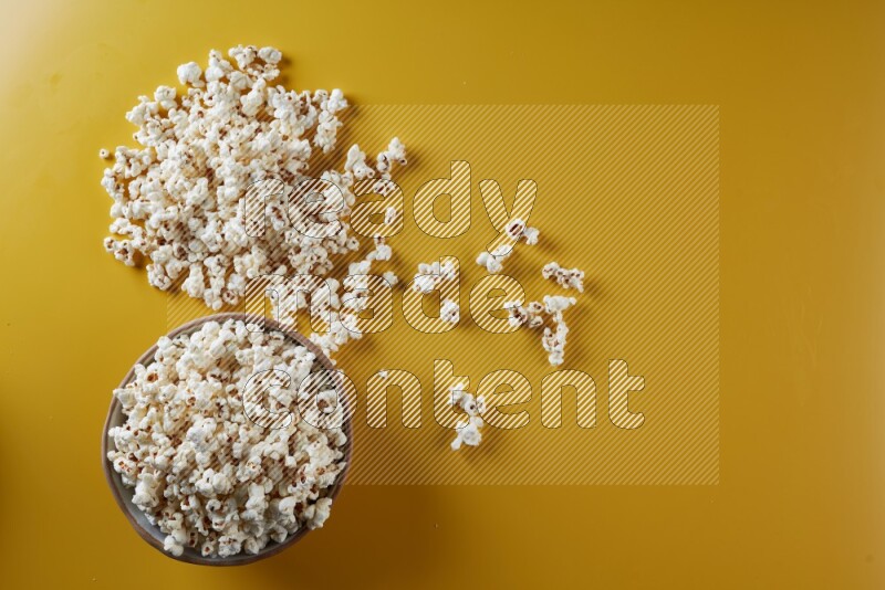A brown pottery bowl full of popcorn with popcorn beside it on a yellow background in different angles